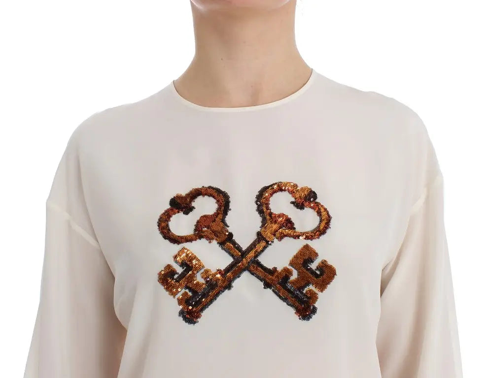Top blanc crème à manches longues dolce & gabbana en soie avec motif clé en sequins dorés et marron foncé
