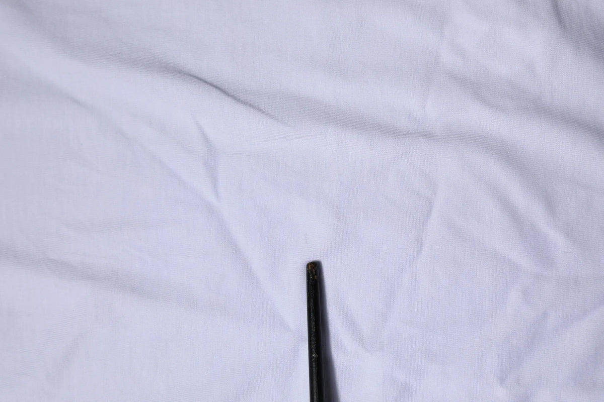Objet cylindrique noir légèrement usé associé au t shirt dolce & gabbana blanc à manches courtes col rond