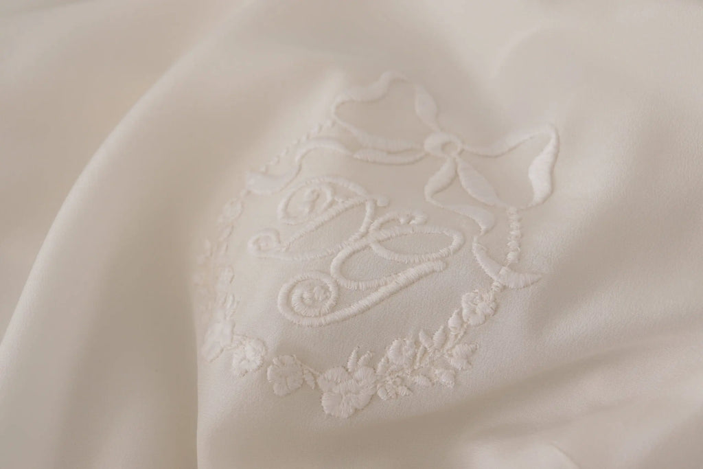 Blouse à manches longues dolce & gabbana en soie blanche avec monogramme brodé délicat et détails floraux