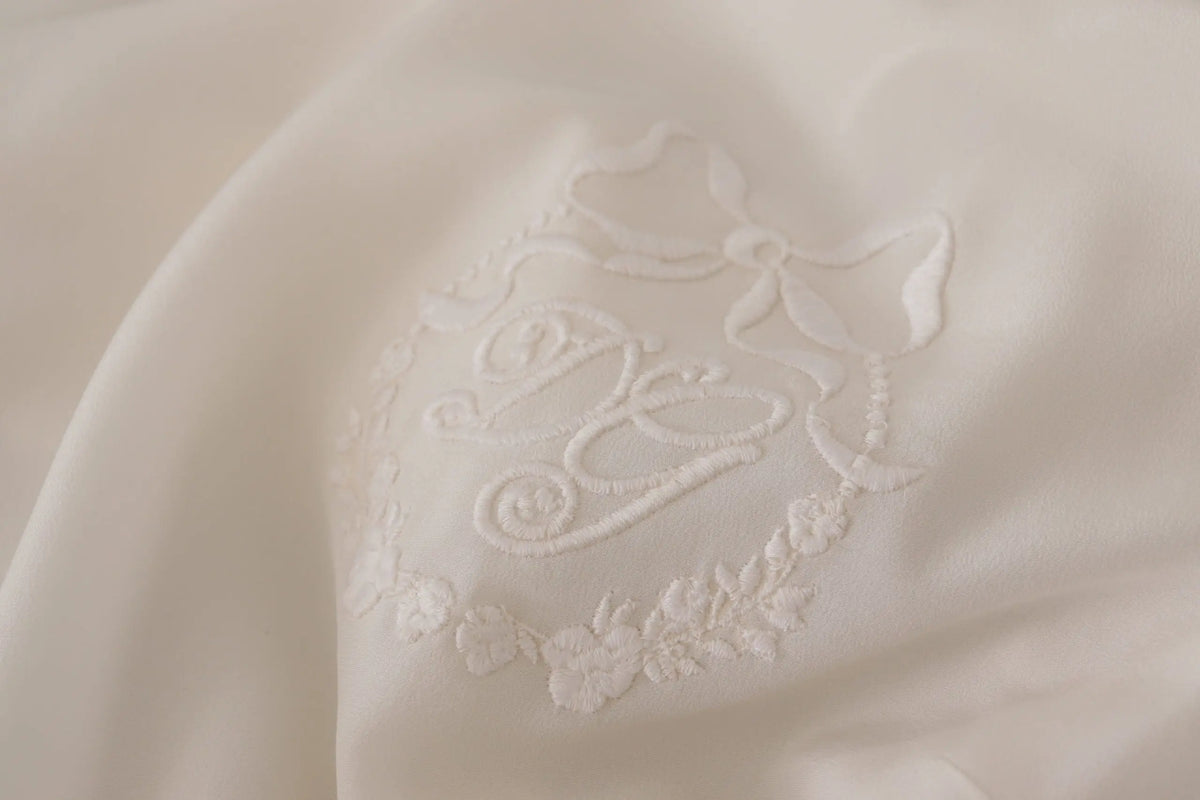 Blouse à manches longues dolce & gabbana en soie blanche avec monogramme brodé délicat et détails floraux
