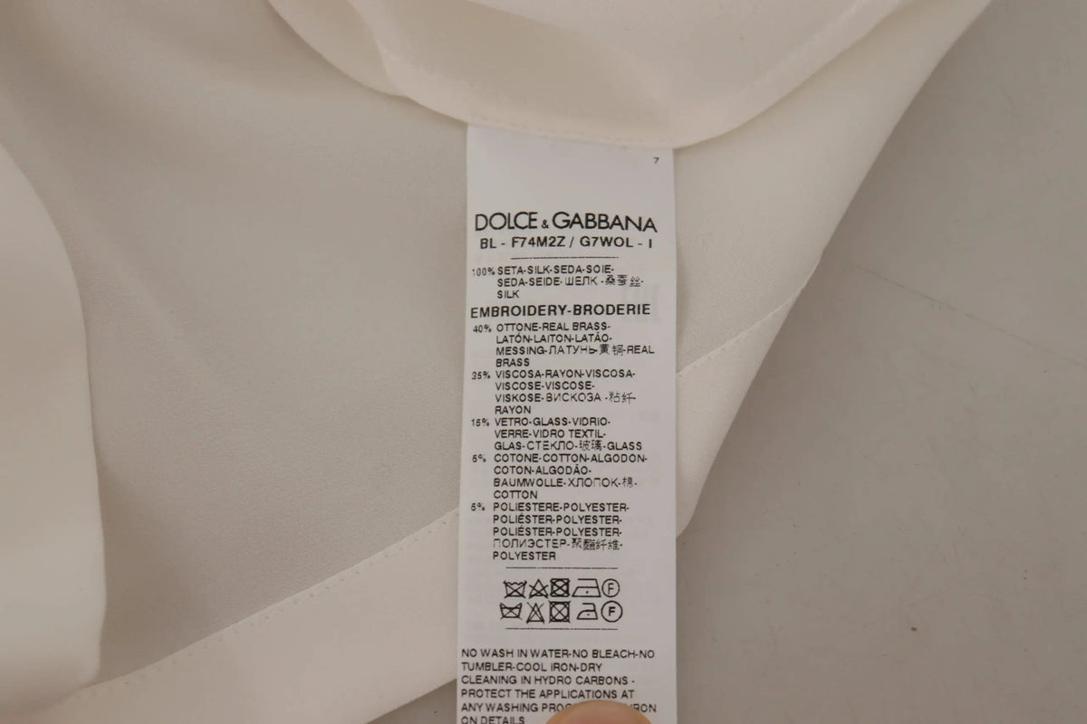 Étiquette d entretien multilingue au dos d un chemisier blanc en soie avec couronne dorée et cristaux dolce gabbana