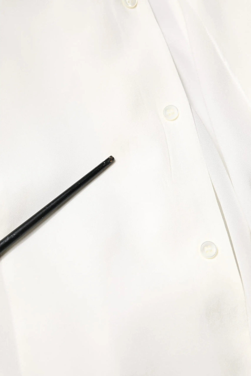 Stylo noir cylindrique posé sur une chemise formelle blanche en soie Dolce & Gabbana à col classique en or