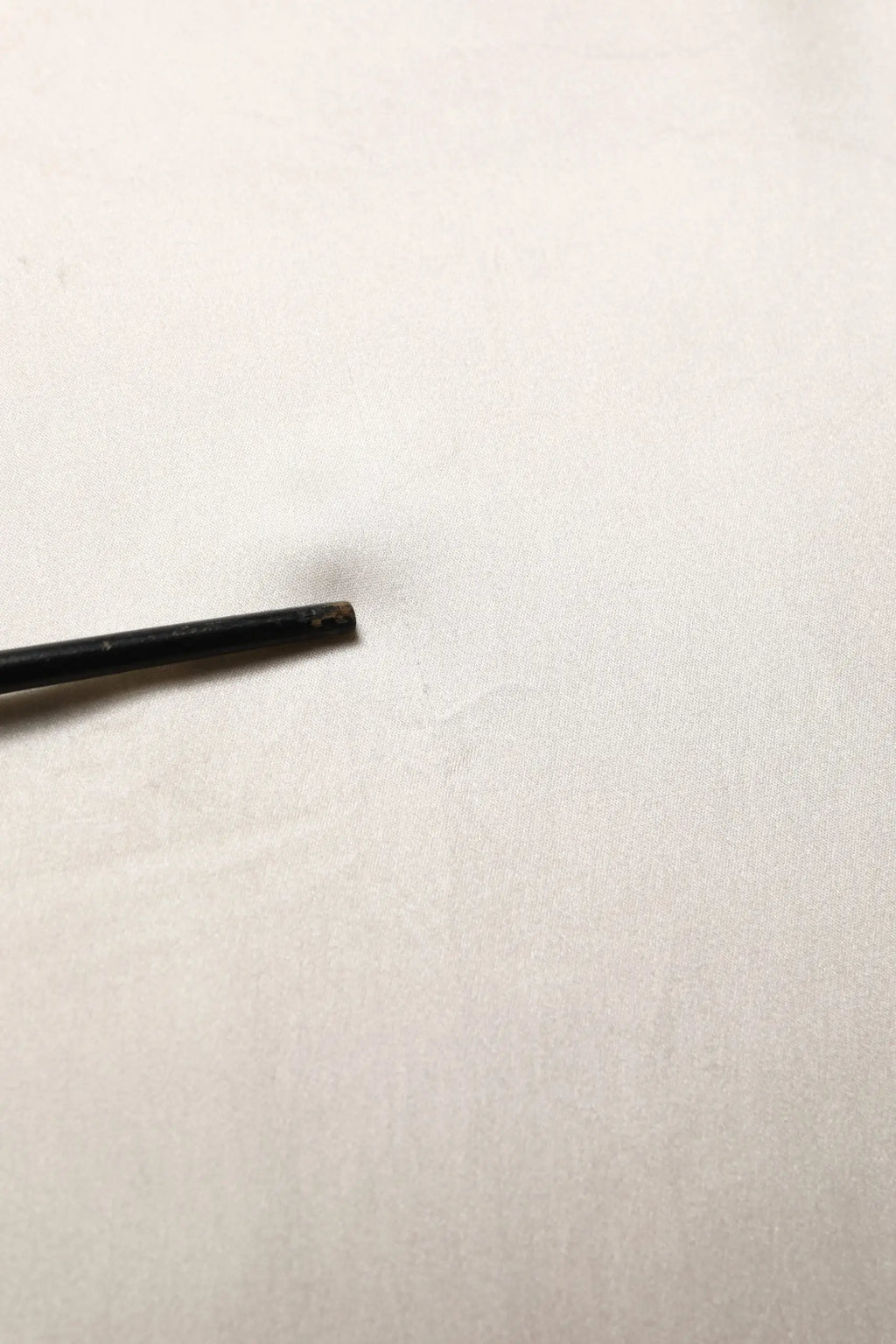 Barillet de stylo cylindrique noir avec pull col roulé blanc en soie à manches longues dolce gabbana