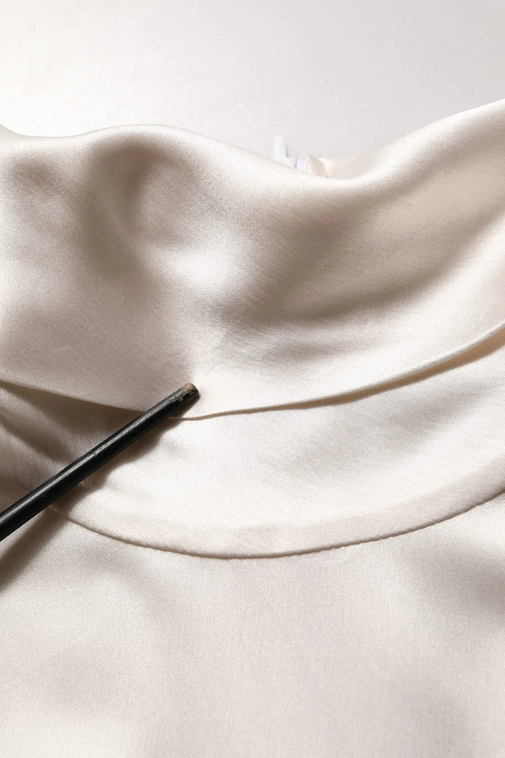 Un pull col roulé dolce & gabbana en soie blanche avec manches longues en satin doux ivoire aux plis légers