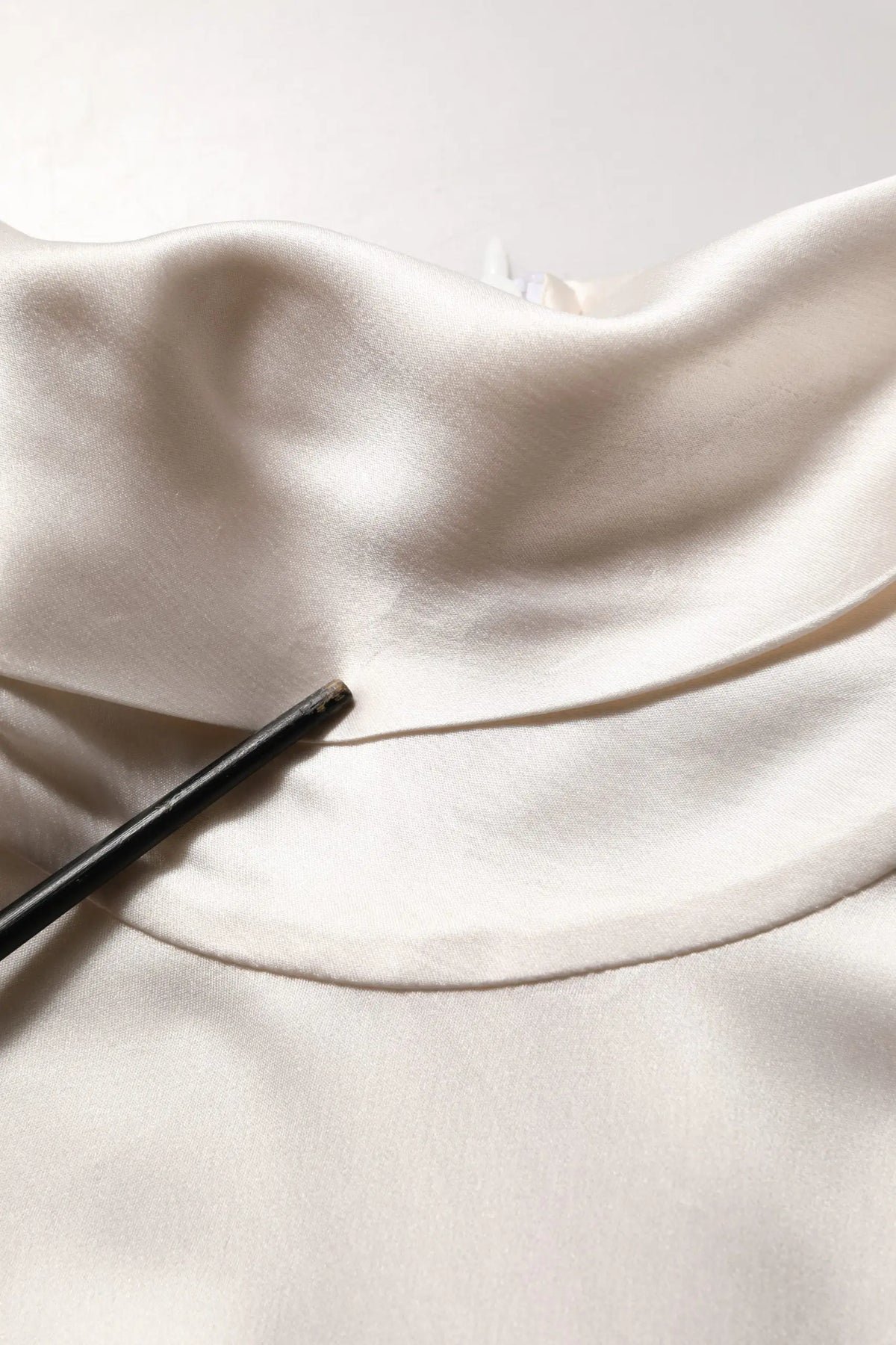 Un pull col roulé dolce & gabbana en soie blanche avec manches longues en satin doux ivoire aux plis légers