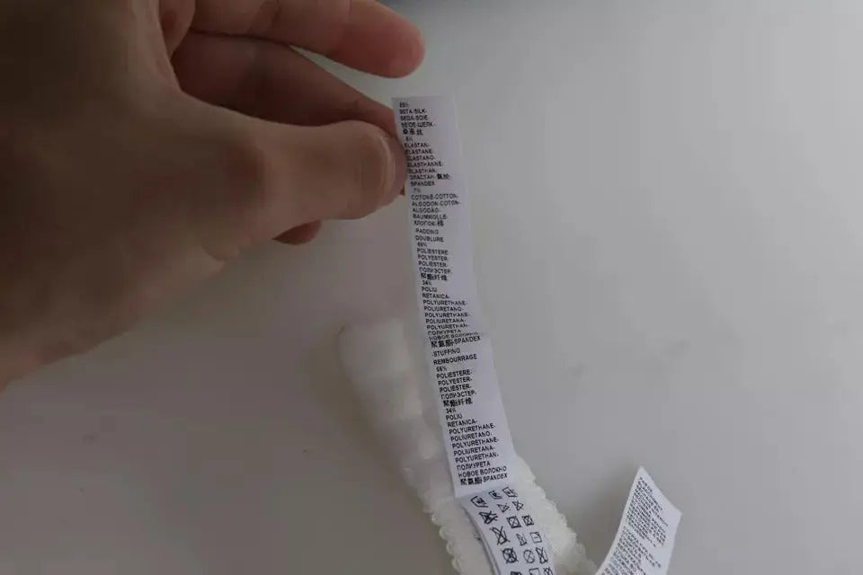 Étiquette d entretien en tissu blanc avec texte noir attachée à un vêtement texturé blanc pour dolce gabbana culotte balconnet en soie extensible blanche