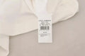 Étiquette blanche dolce & gabbana en coton mélangé avec texte noir et code-barres indiquant origine italienne sur pullover rayé manches courtes blanc