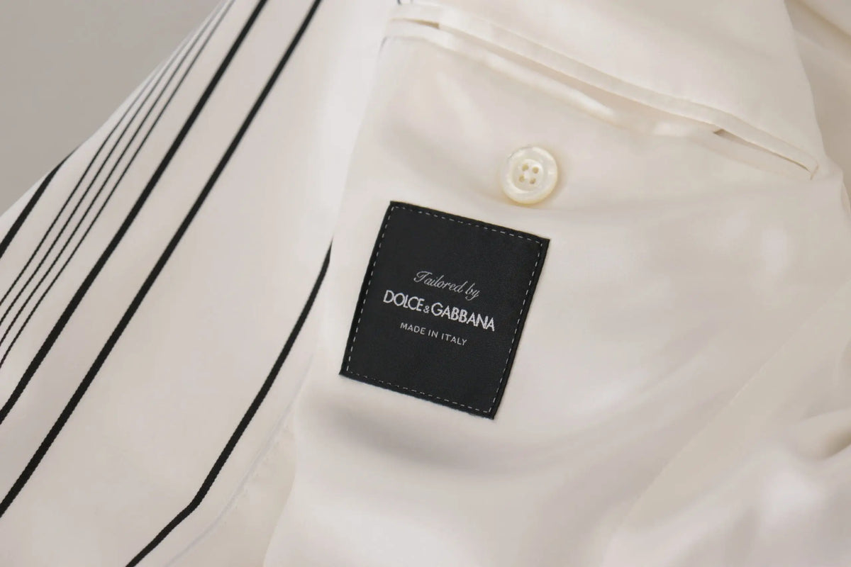 Étiquette noire avec texte blanc tailored by dolce & gabbana made in italy sur tissu crème dun blazer blanc rayé en coton