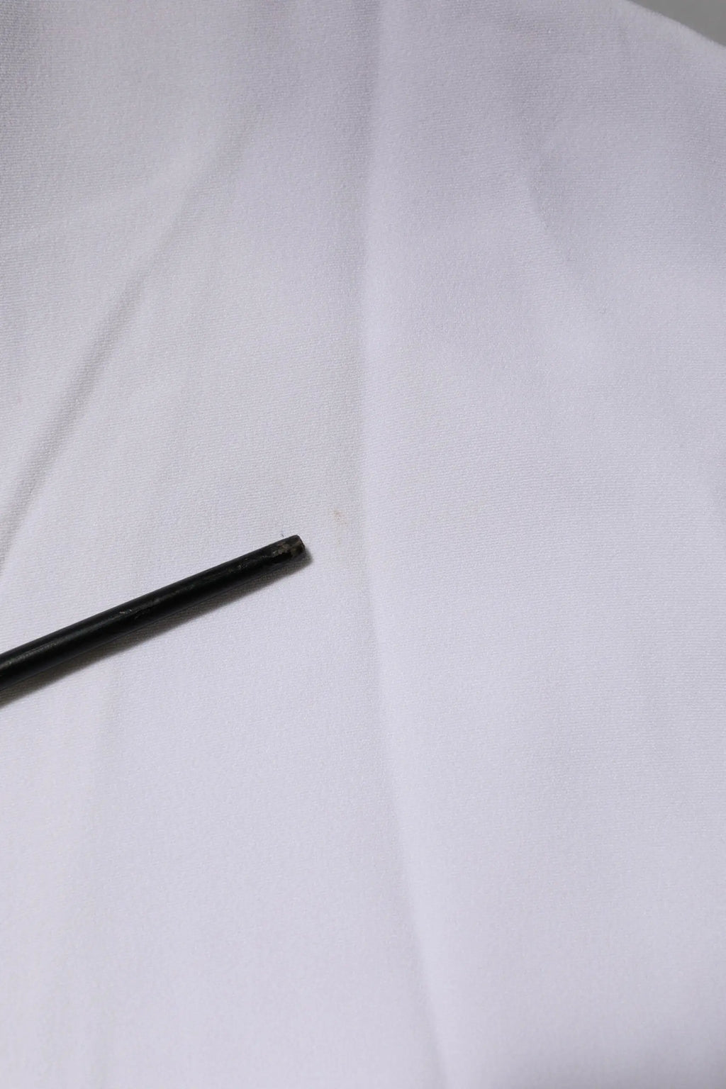 Stylo cylindrique noir mat avec finition mate présenté avec veste femme dolce gabbana blanche en viscose à fermeture éclair complète