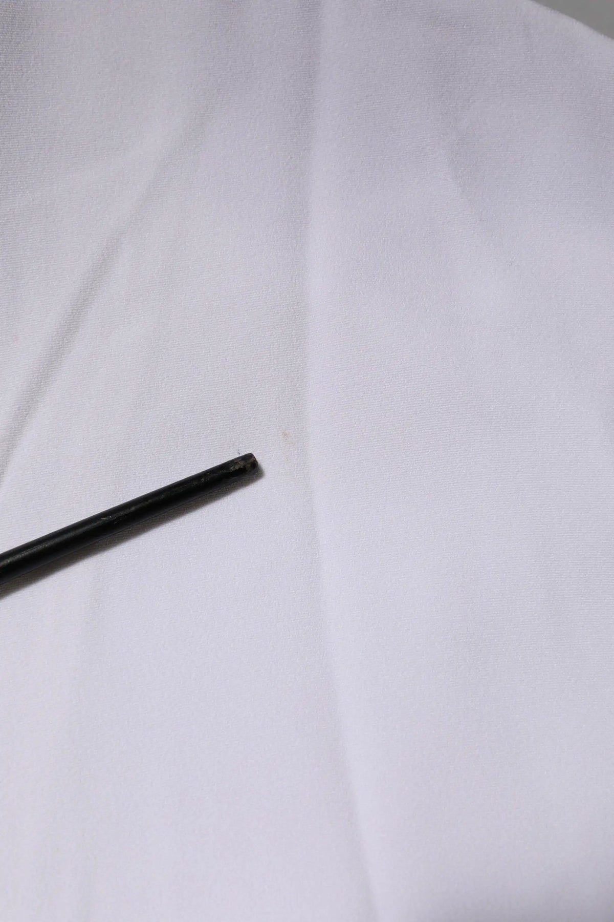Stylo cylindrique noir mat avec finition mate présenté avec veste femme dolce gabbana blanche en viscose à fermeture éclair complète