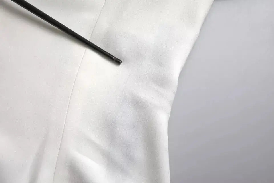 Un outil cylindrique noir élégant posé en diagonale sur un top blanc en viscose à manches courtes Dolce & Gabbana
