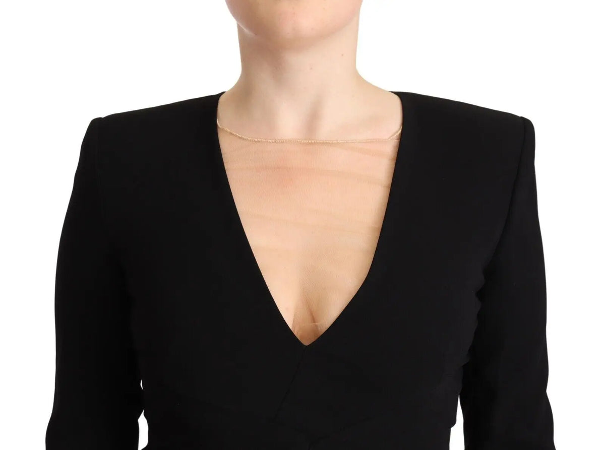 Une chaîne en or délicate portée avec une robe mini Dsquared² noire à manches longues et col en v profond