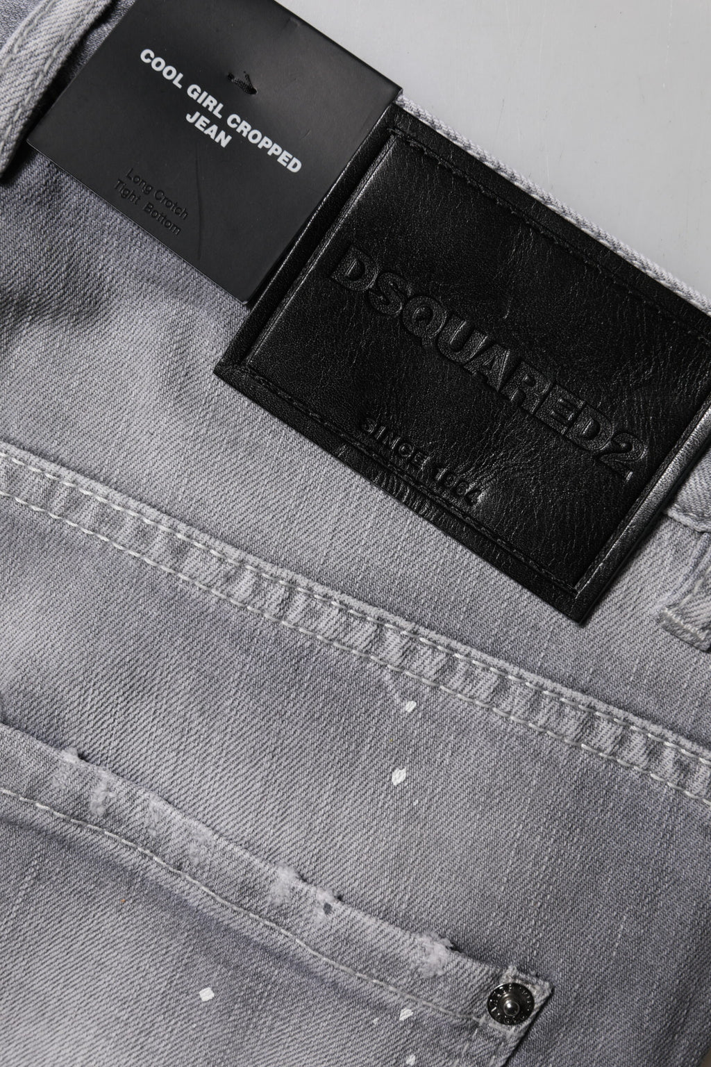 Jeans gris délavé à taille moyenne et coupe tapered de Dsquared², visibles avec détails usés et finitions modernes.