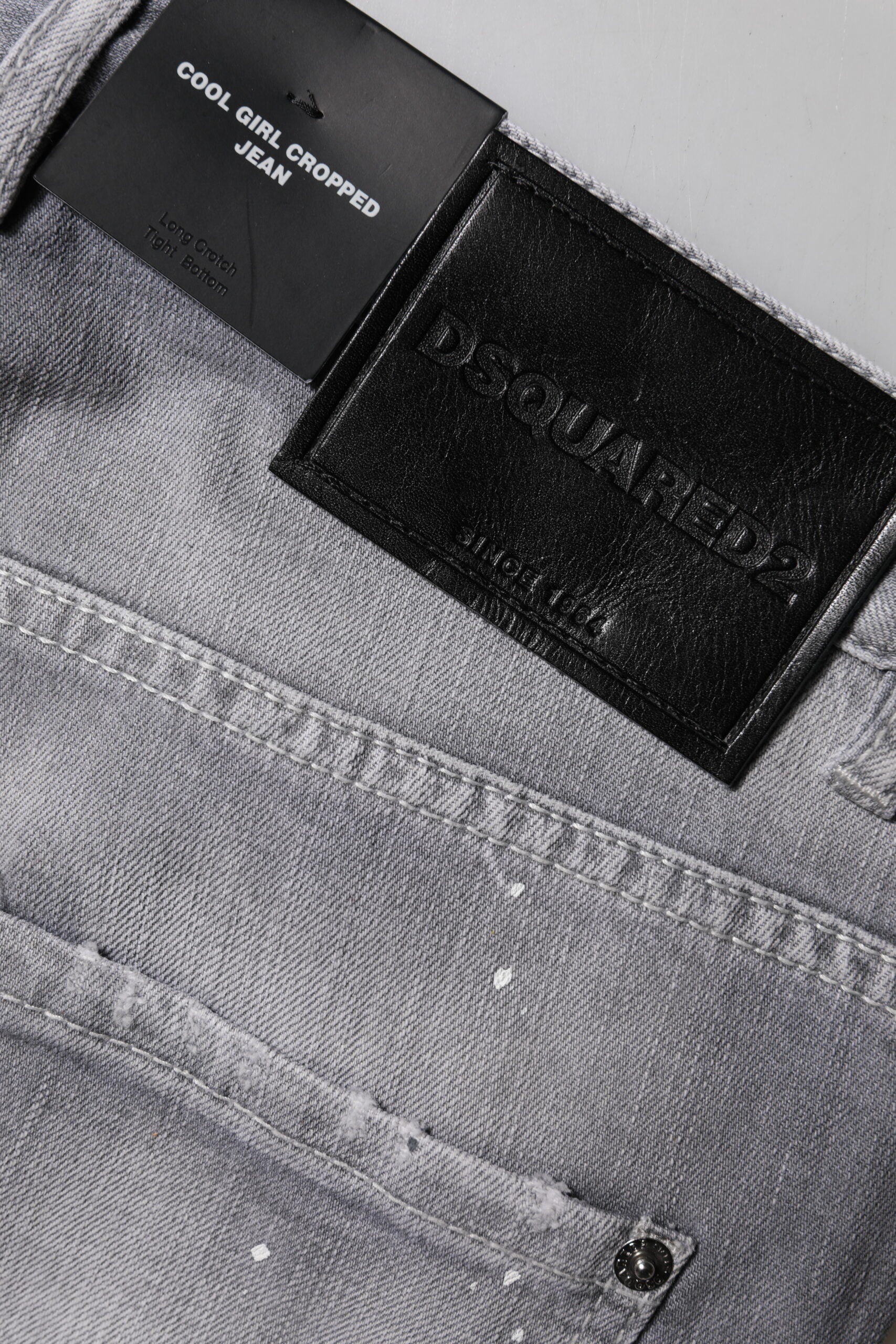 Jeans gris délavé à taille moyenne et coupe tapered de Dsquared², visibles avec détails usés et finitions modernes.
