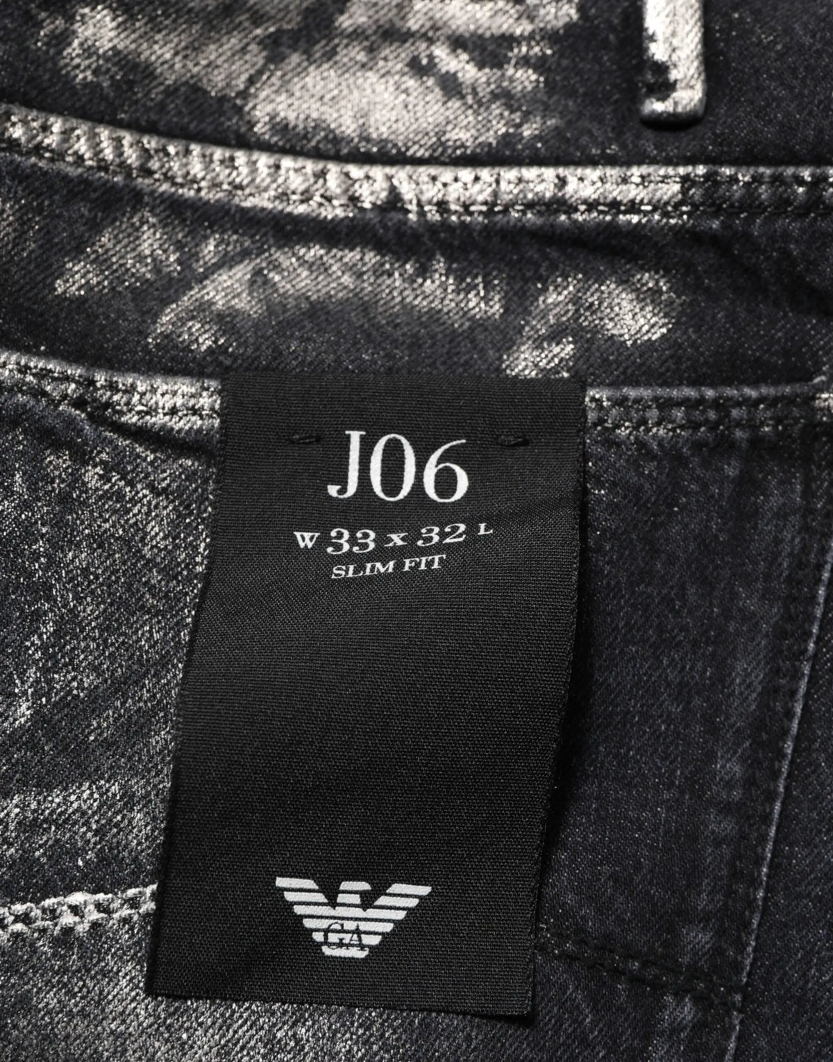 Empirio armani jean slim fit homme en denim noir délavé avec texture usée et étiquette de marque visible