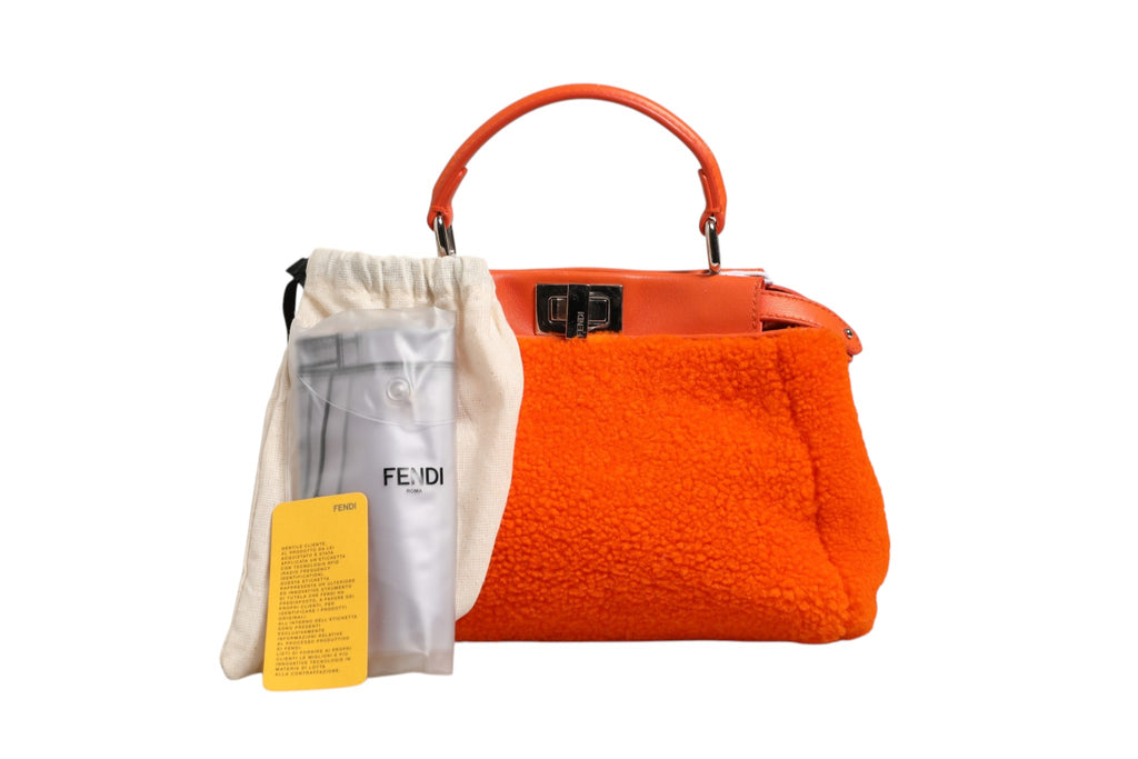 Sac à main Fendi Peekaboo mini en cuir orange et shearling, poignées en haut, avec détails de finition élégants.