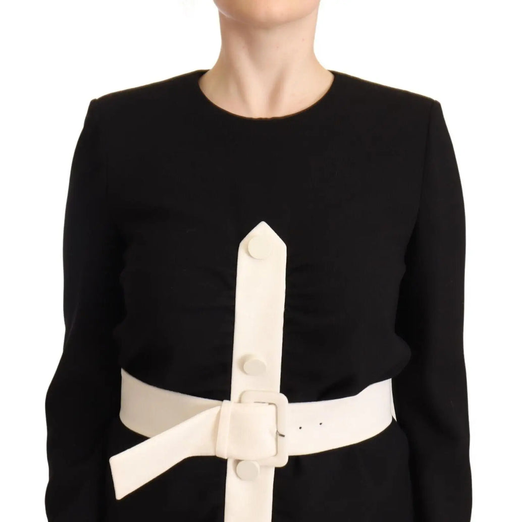 Une ceinture blanche en cuir lisse avec boucle minimaliste et trois boutons décoratifs sur la robe noire Givenchy en laine