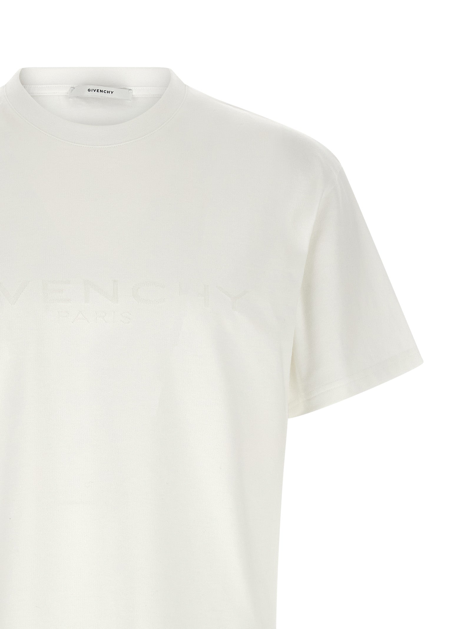 T-shirt blanc en coton Givenchy, style décontracté avec logo subtil, porté sur mannequin.