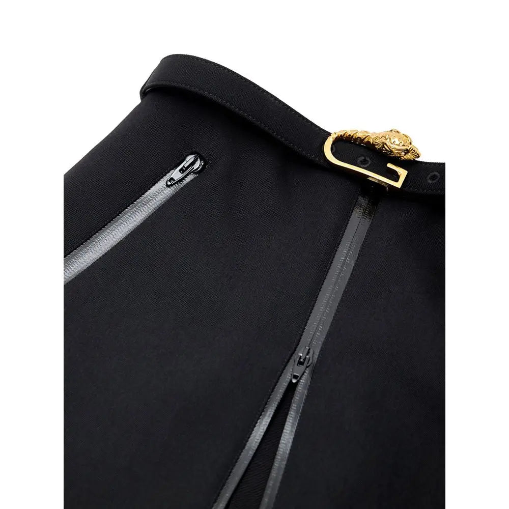 Sac Versace noir avec fermoir tête de méduse doré et fermetures éclair argentées sous un jupe mi-longue en laine noire Gucci