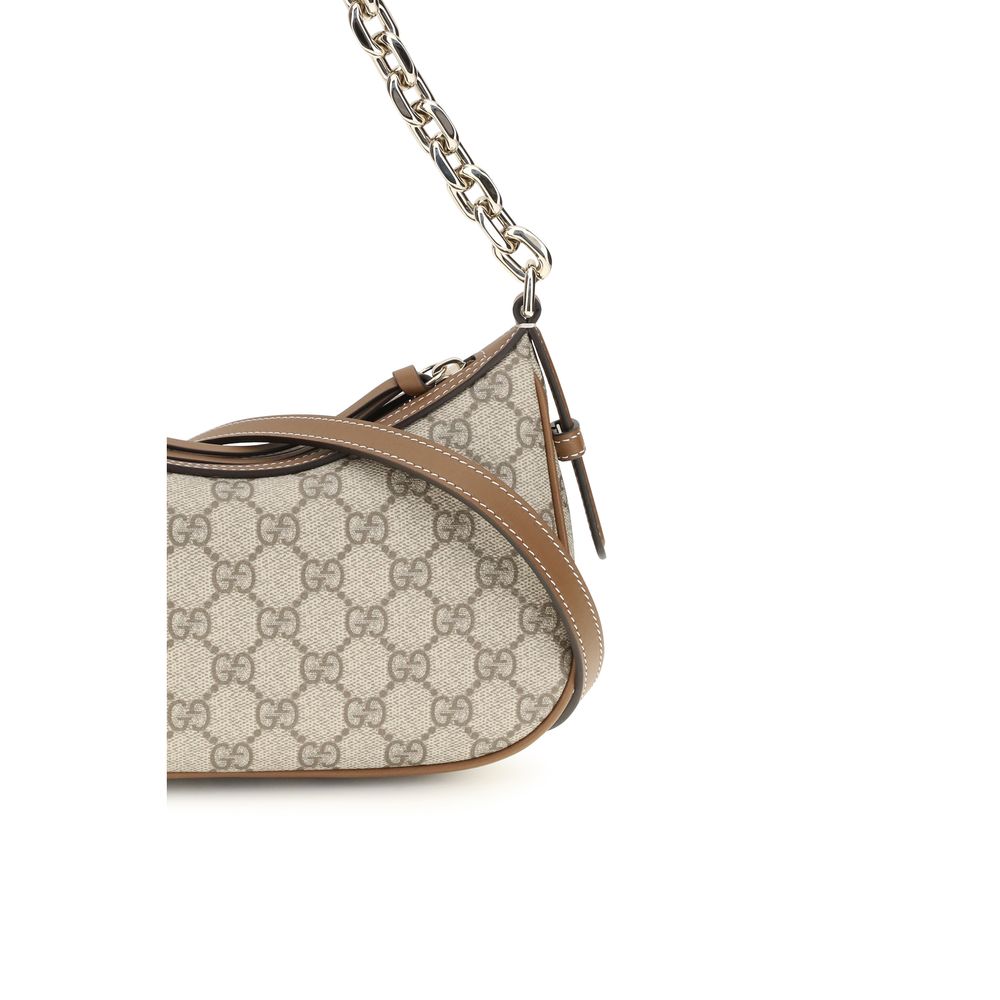 Sac à main en tissu beige de Gucci avec logo emblématique, détails élégants et bandoulière ajustable.
