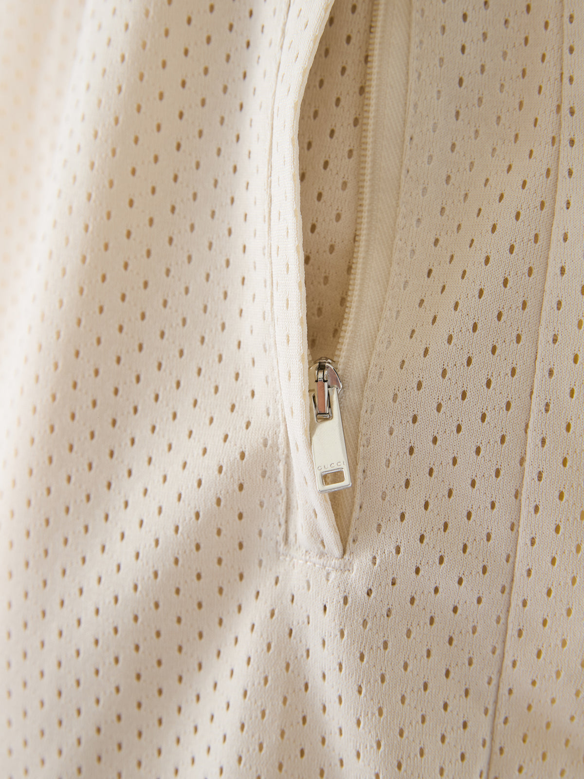 Shorts en polyester crème Gucci avec logo, style décontracté, tissu léger, vue de face sur fond blanc.