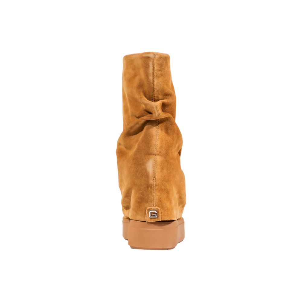 Bottes en cuir suédé beige de la marque Guess, ankle, avec talon moyen et finition élégante, visibles en gros plan.