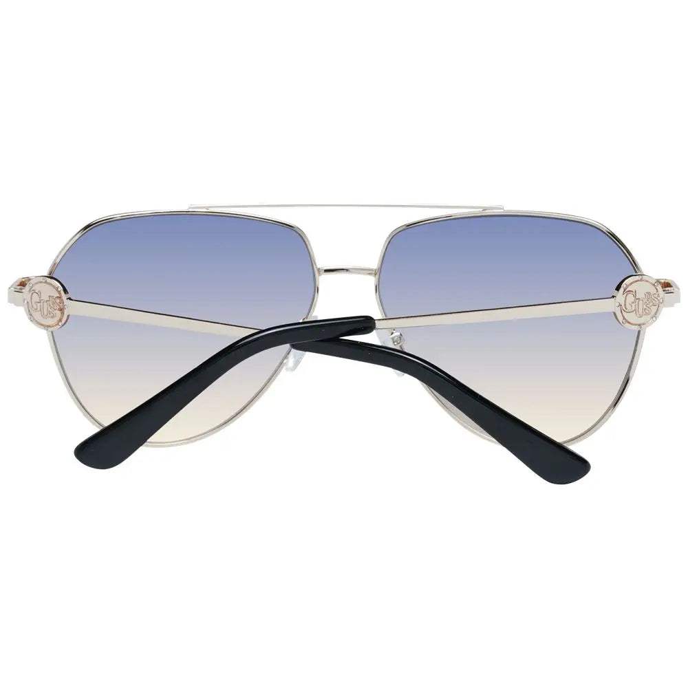 Lunettes de soleil guess en métal doré avec monture argentée, verres dégradés bleu à blanc et logo circulaire sur les branches