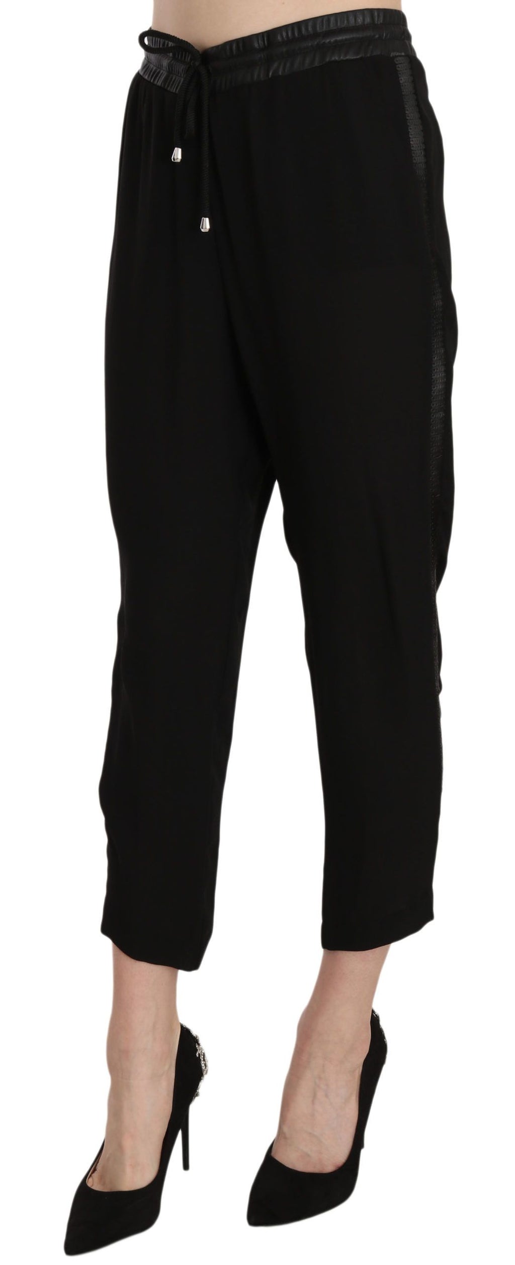 Pantalon noir en polyester à taille haute et coupe courte de la marque Guess, visible avec détails de la texture.