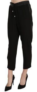 Pantalon noir en polyester à taille haute et coupe courte de la marque Guess, visible avec détails de la texture.