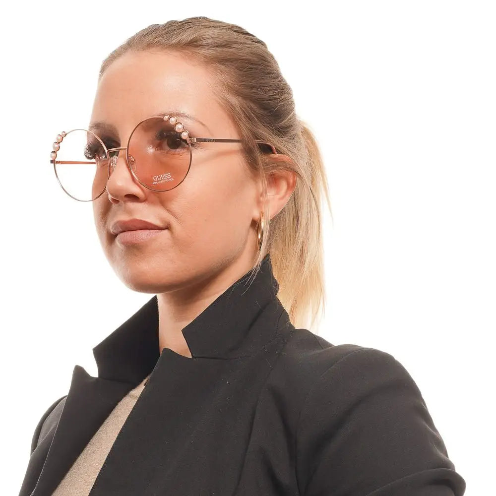 Lunettes de soleil rondes en métal rose gold avec perles et logo Guess sur le verre