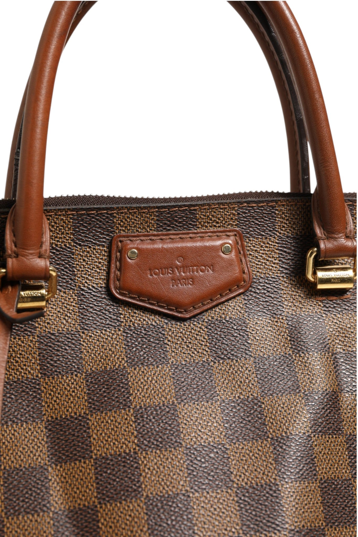 Sac cabas Louis Vuitton Damier Ebene Belmont avec motif à damier, poignée en cuir et fermeture métallique visible.