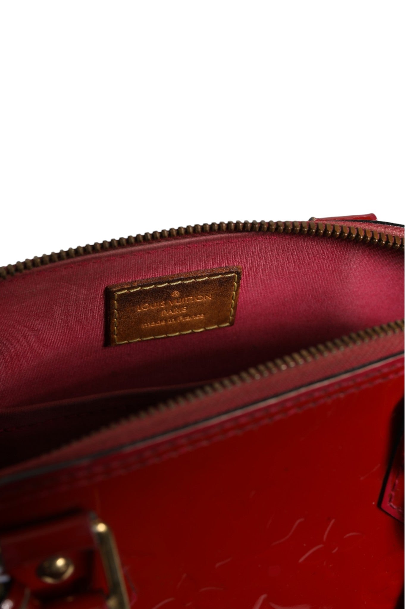 Sac Louis Vuitton Alma BB en vernis monogramme Pomme D'Amour, élégant et brillant, avec double poignée et fermeture métallique.