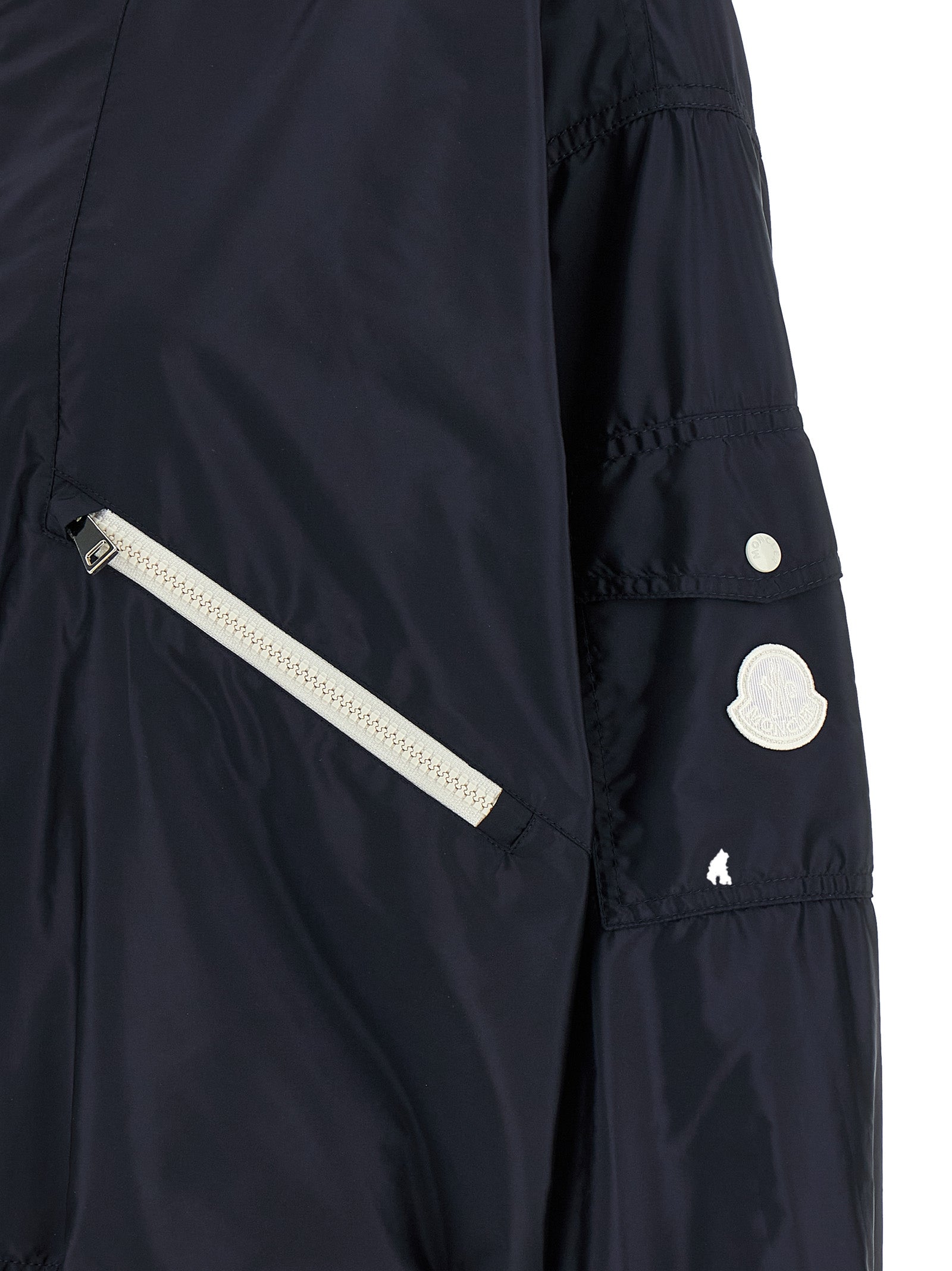 Veste Moncler en polyamide bleu, coupe-vent et légère, avec capuche et fermeture éclair visible.