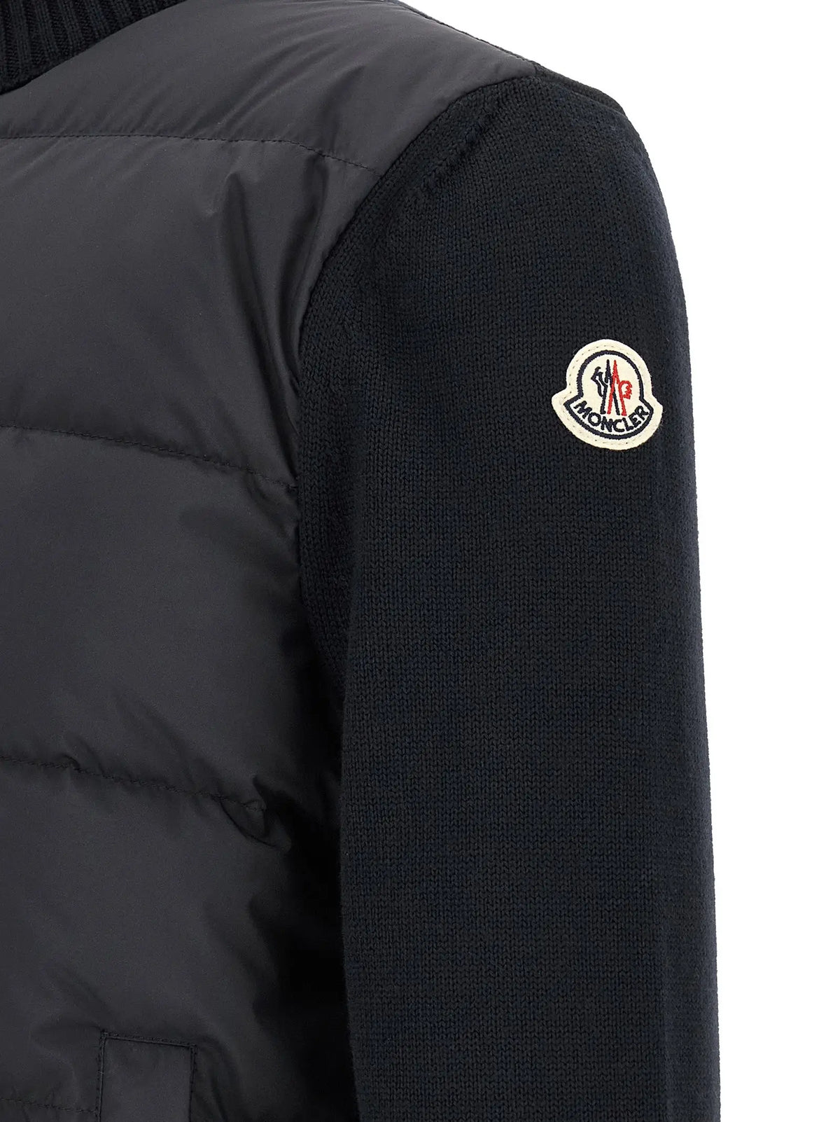 Veste matelassée moncler noire avec manches en maille et logo emblématique sur l’épaule en polyester bleu