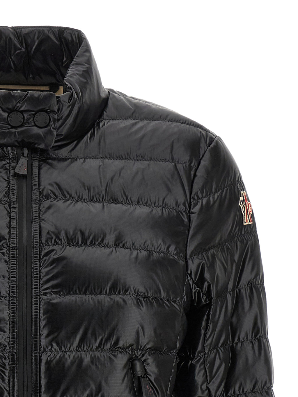 Veste longue en polyamide noire Moncler Grenoble, style élégant et chaud, visible avec fermeture éclair et capuche intégrée.