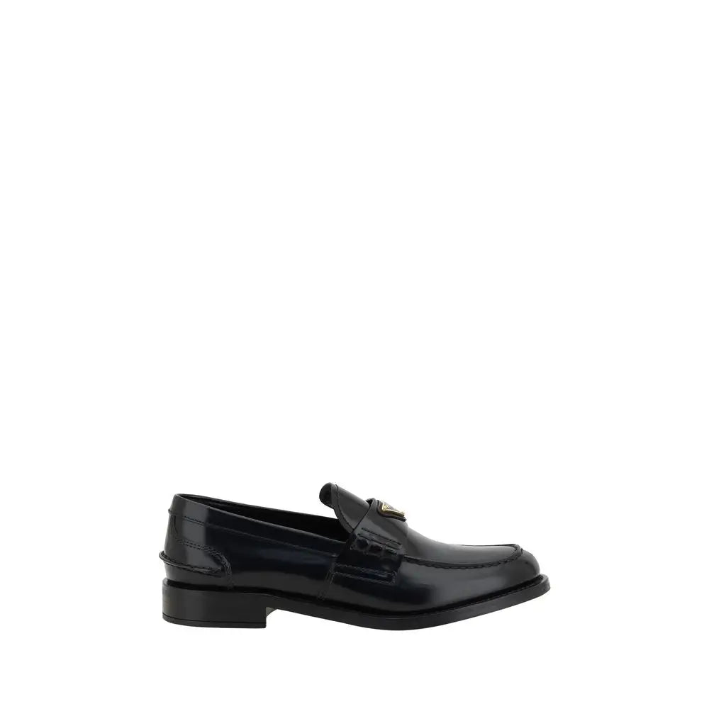 Prada black leather loafers with glossy patent finish and gold-tone triangular logo on the vamp
