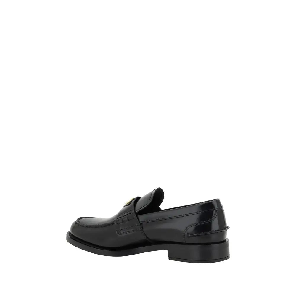 Prada black leather loafers with polished patent finish and subtle gold-tone logo on the vamp