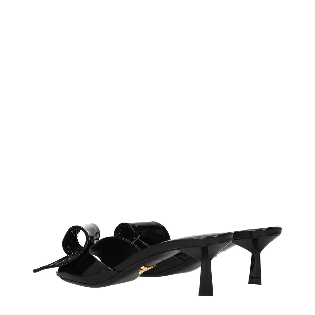 Mule sandal prada en cuir noir verni avec nœud proéminent et détail en métal doré