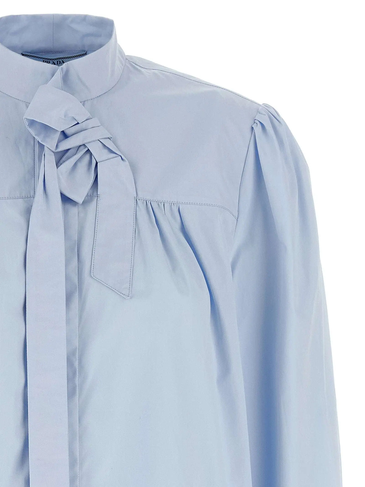 Blouse bleue en coton prada avec col montant et nœud noué au niveau du col