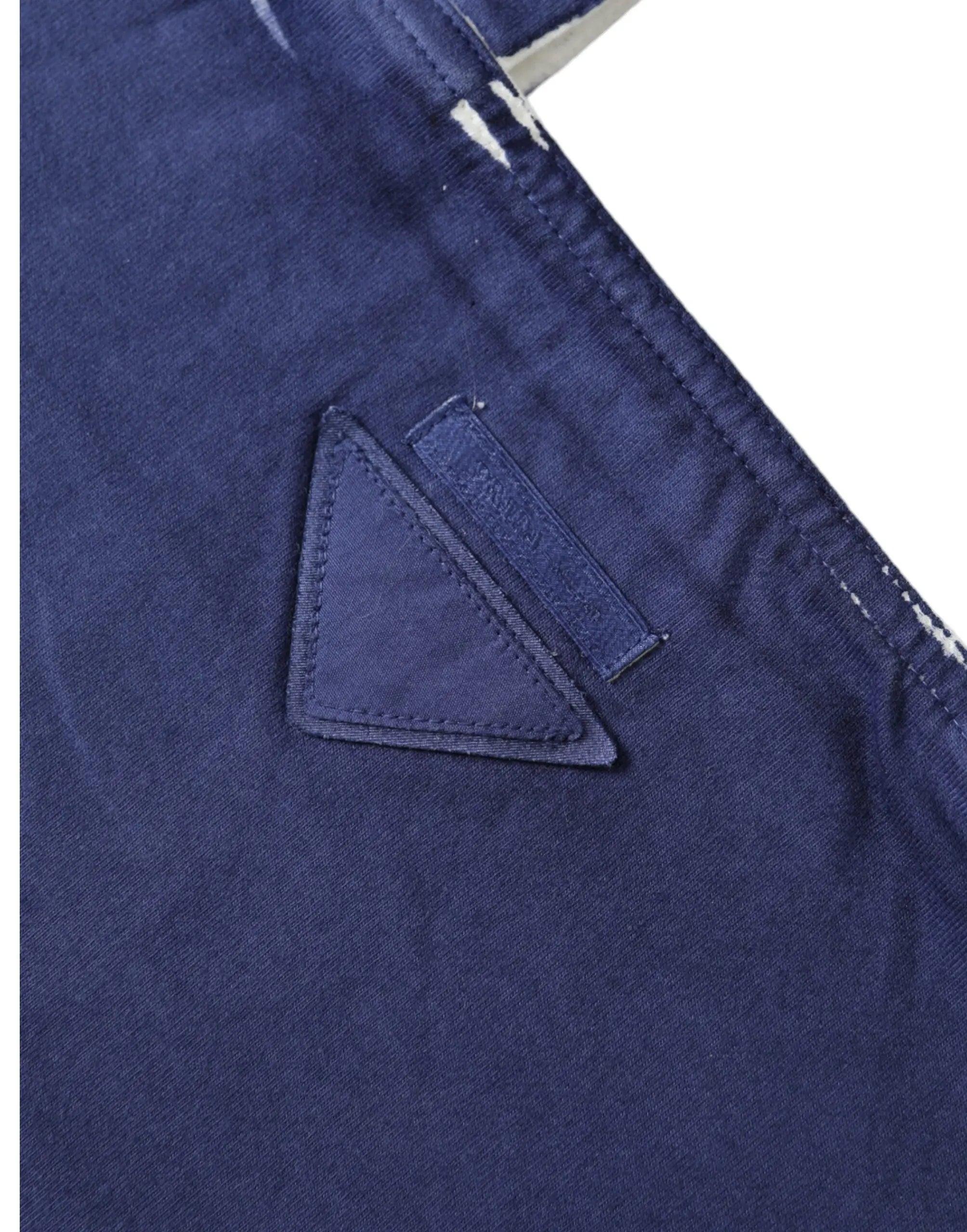 Patch triangulaire bleu foncé avec bords cousus et étiquette rectangulaire sur le sac shopping épaule prada en jersey bleu