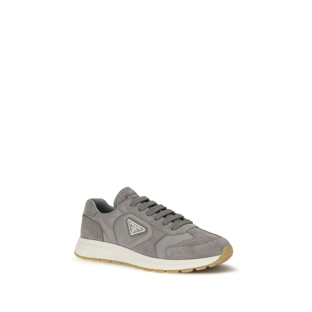 Chaussures de sport grises Prada en polyamide recyclé, baskets athlétiques élégantes avec semelle blanche.