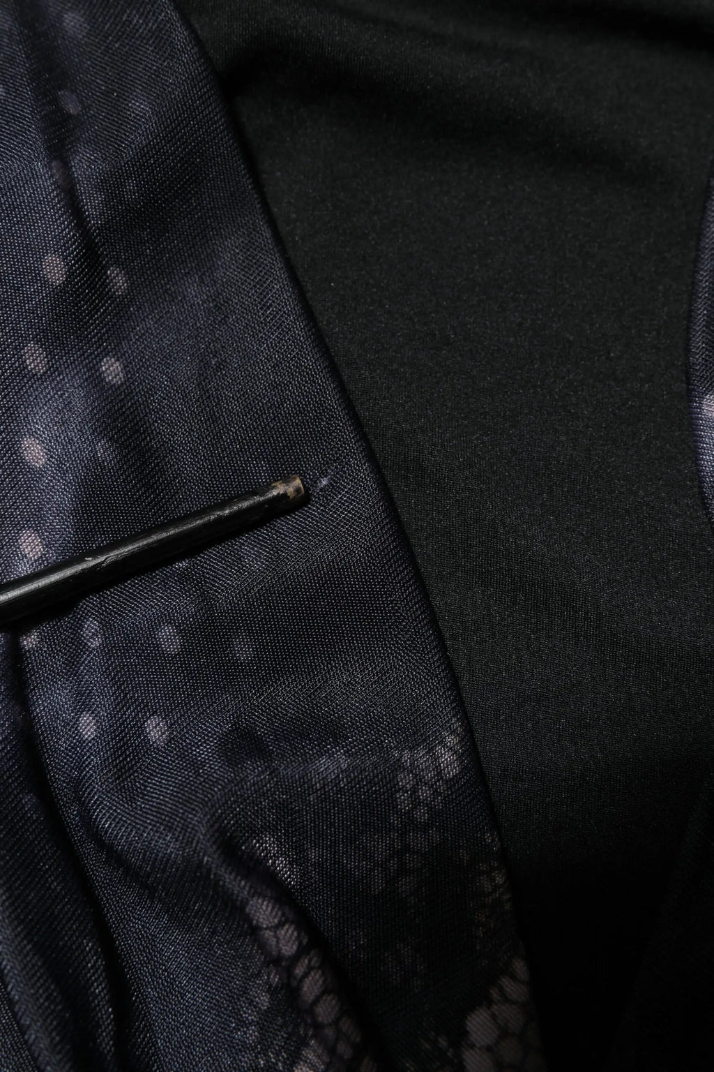 Stylo noir posé sur tissu sombre à pois blancs et dentelle pour robe fourreau midi en viscose à motif floral roberto cavalli