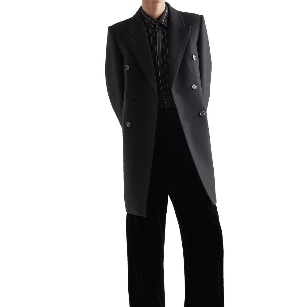 Manteau en laine noir Saint Laurent pour femme, coupe élégante et classique, porté par-dessus une tenue chic.