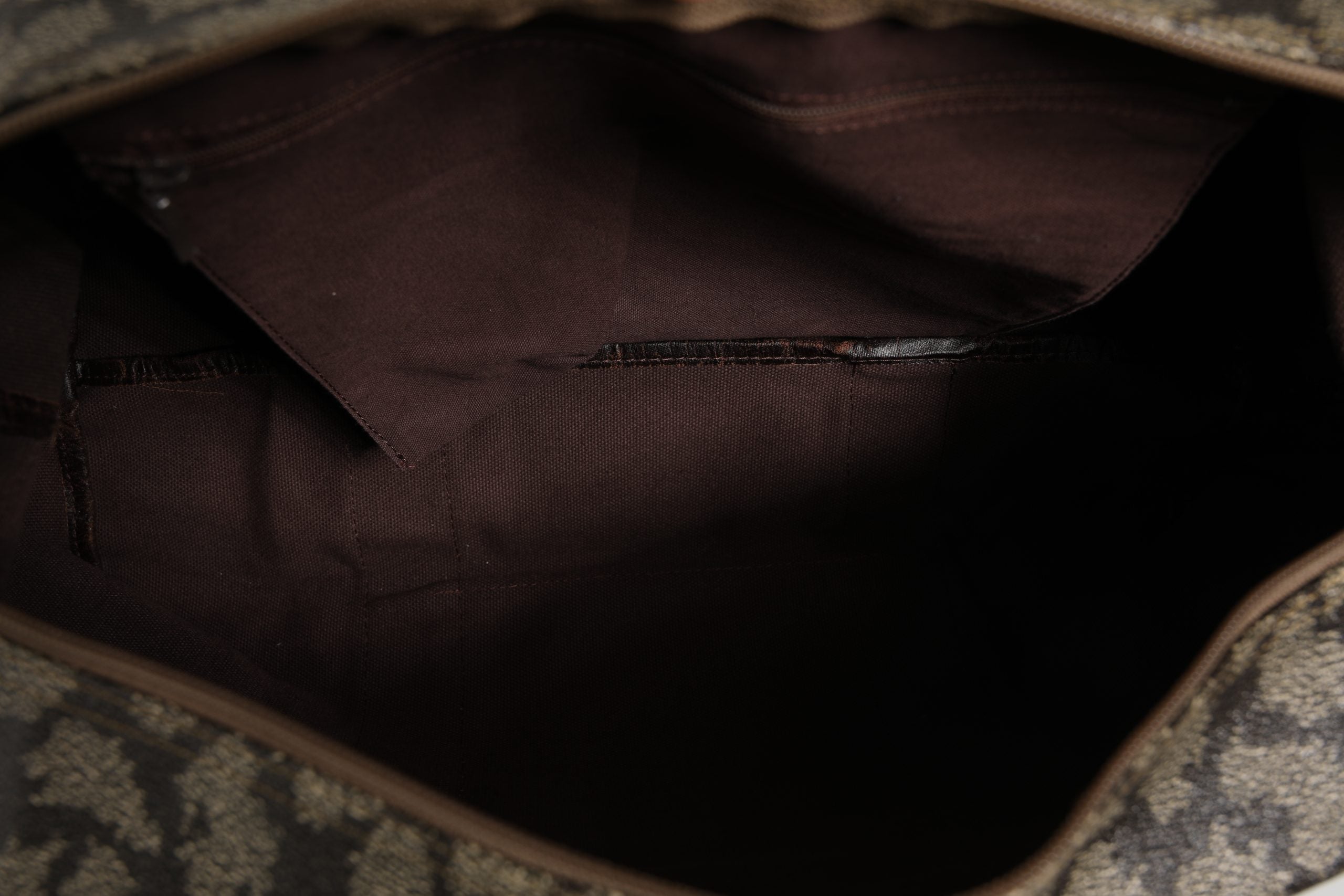 Sac de voyage Saint Laurent en toile à motif vert et marron, avec poignées en cuir et fermeture zippée.