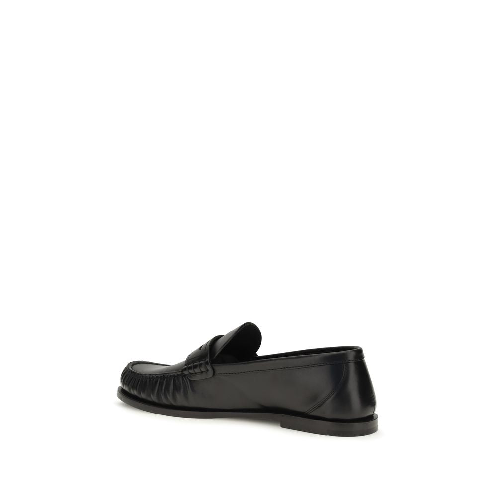 Mocassins Saint Laurent en cuir de veau noir Bos Taurus, slip-on élégants avec finition soignée et semelle en caoutchouc.