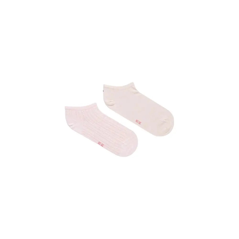 Une paire de chaussettes courtes blanches minimalistes tommy hilfiger en coton avec un logo rose au talon visible de dos