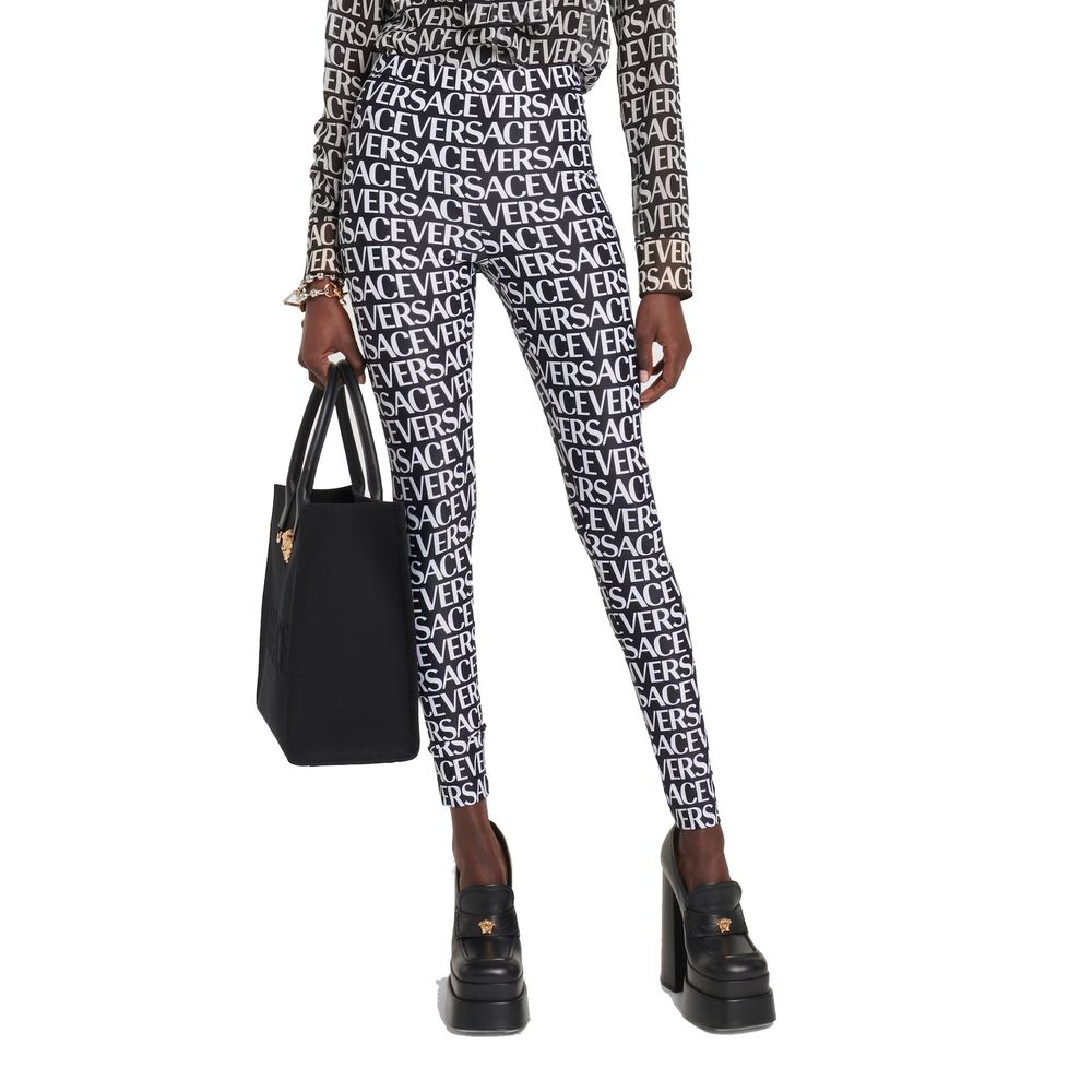 Leggings noires en élasthanne de la marque Versace, ajustées et élégantes, visibles en détail dans l'image.