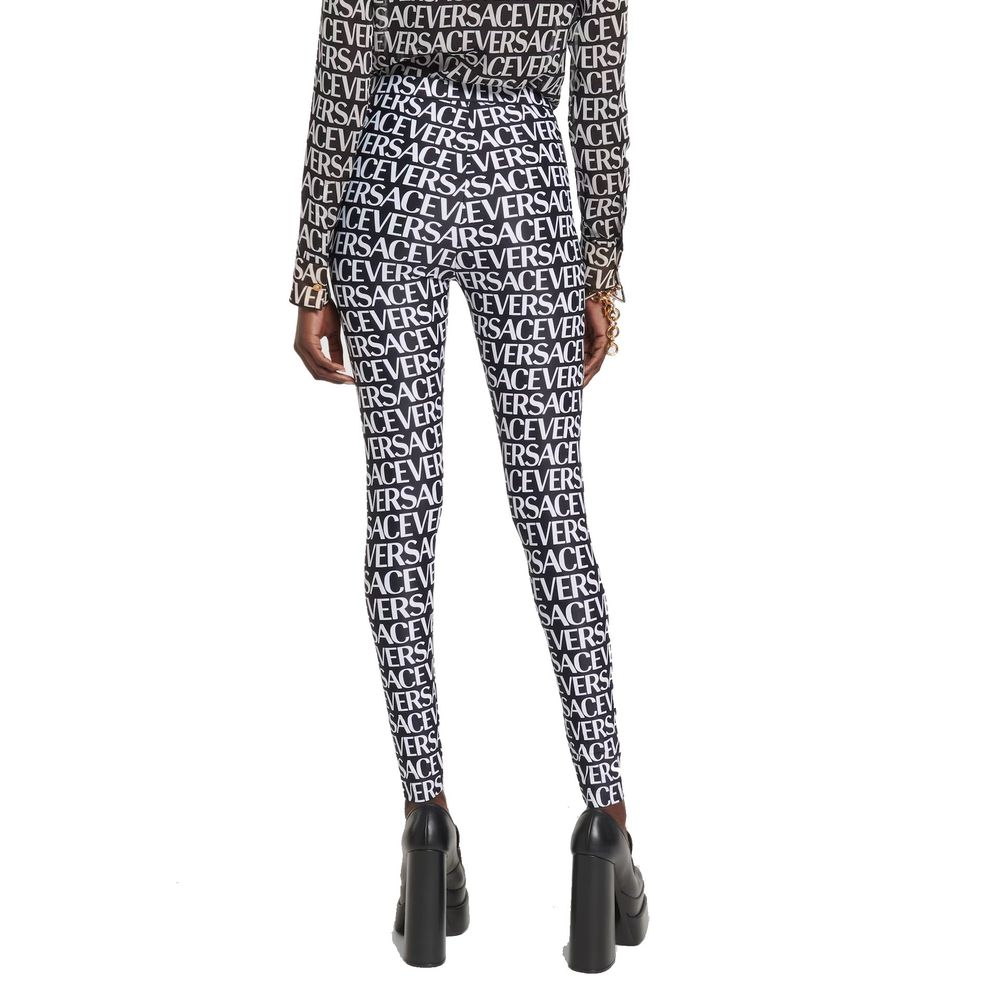 Leggings noires en élasthanne de la marque Versace, ajustés et élégants, avec le logo Versace visible sur la ceinture.