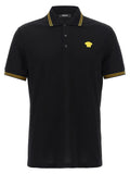 Polo versace noir en coton avec col et manches bordés d or et logo medusa jaune sur la poitrine