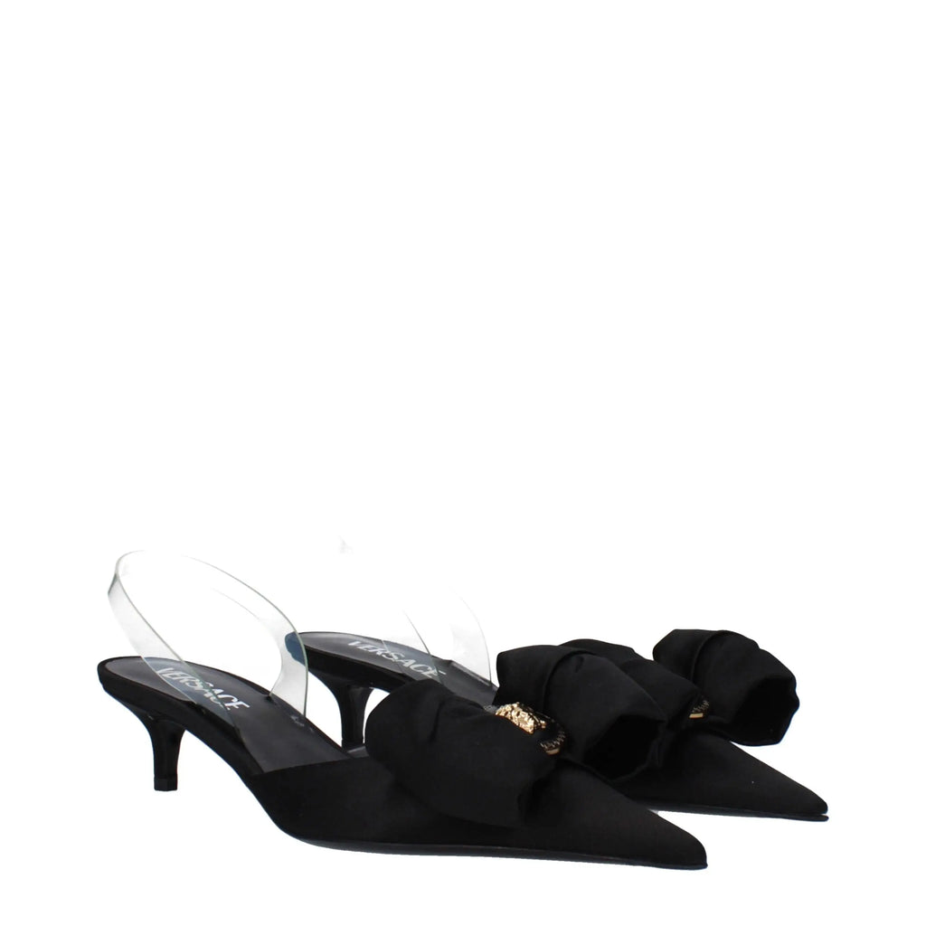 Versace black satin flat sandals in noir avec talons slingback pointus, grand noeud, hardware doré et brides transparentes